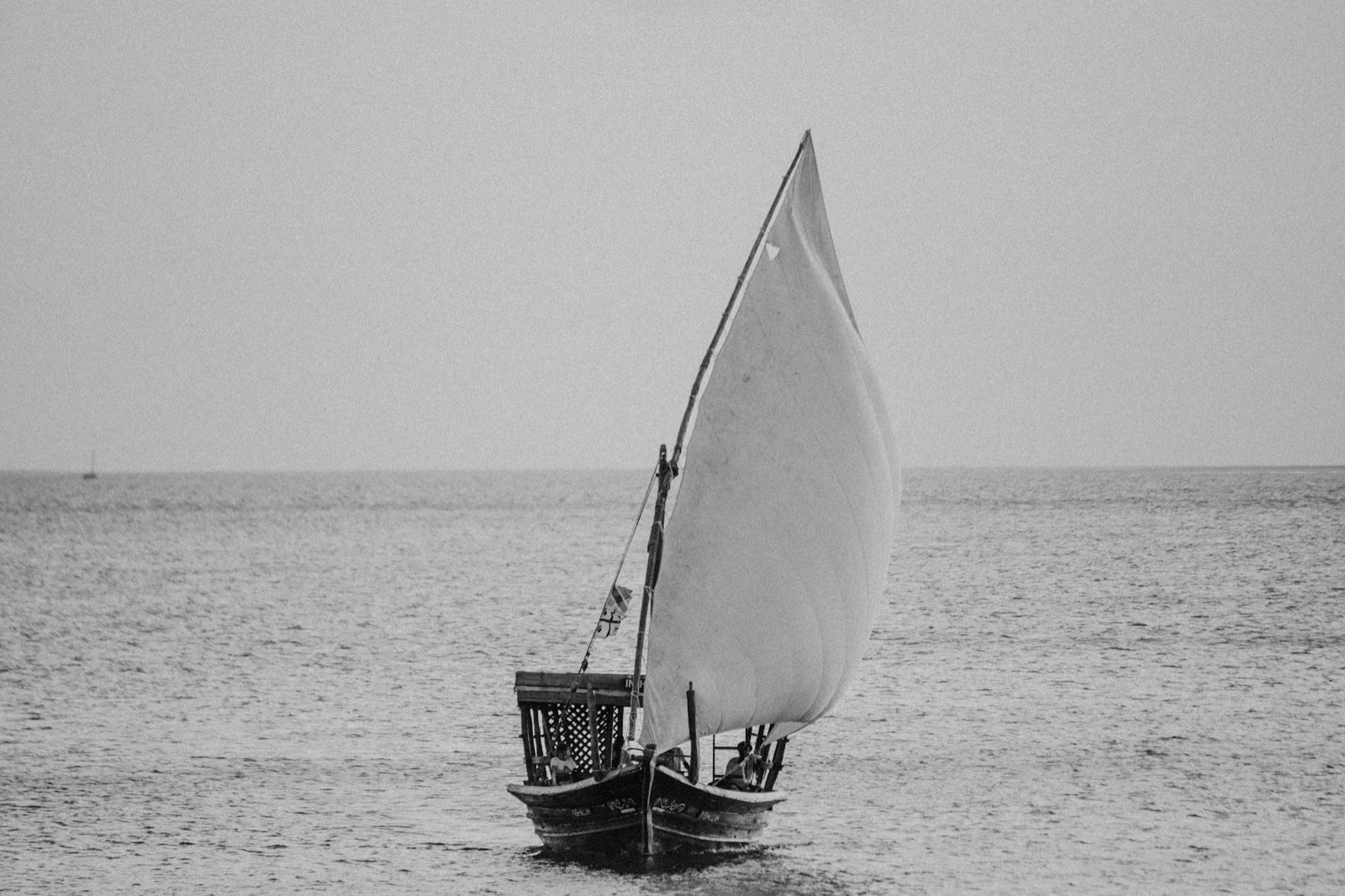 Traditional Zanzibar dhow sailing boat with white lateen sail on the Indian Ocean